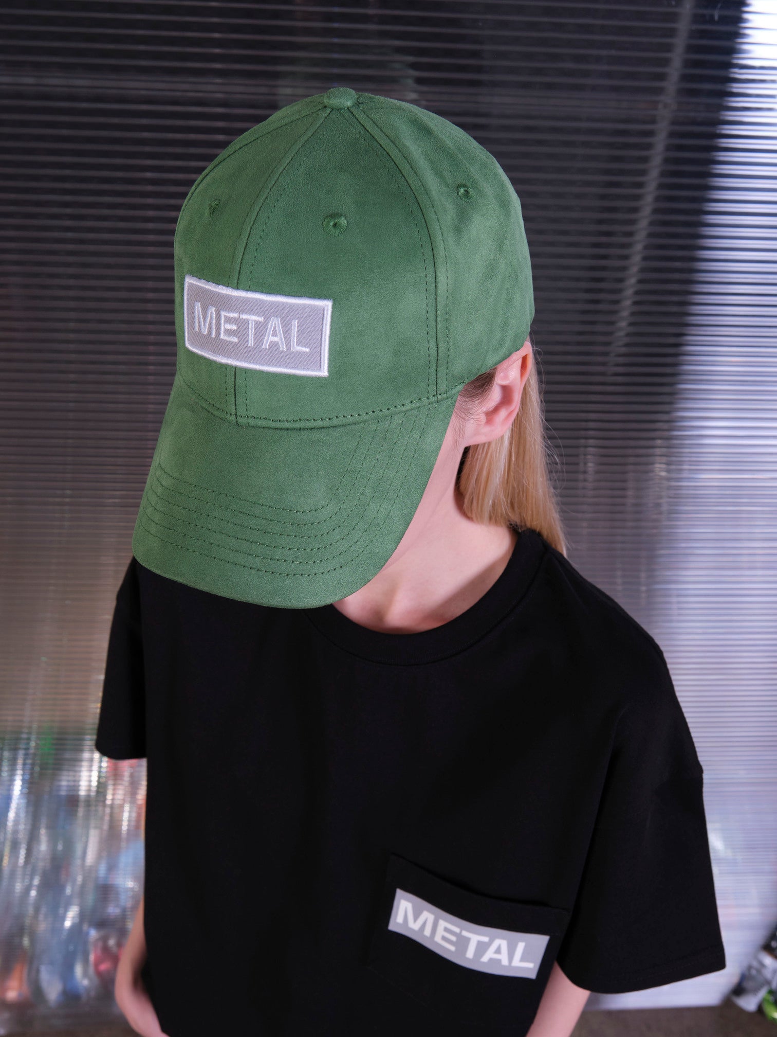 bABP Metal green eco-suede hat from the Signature Collection, portrait view of a female model wearing a black pocket t-shirt