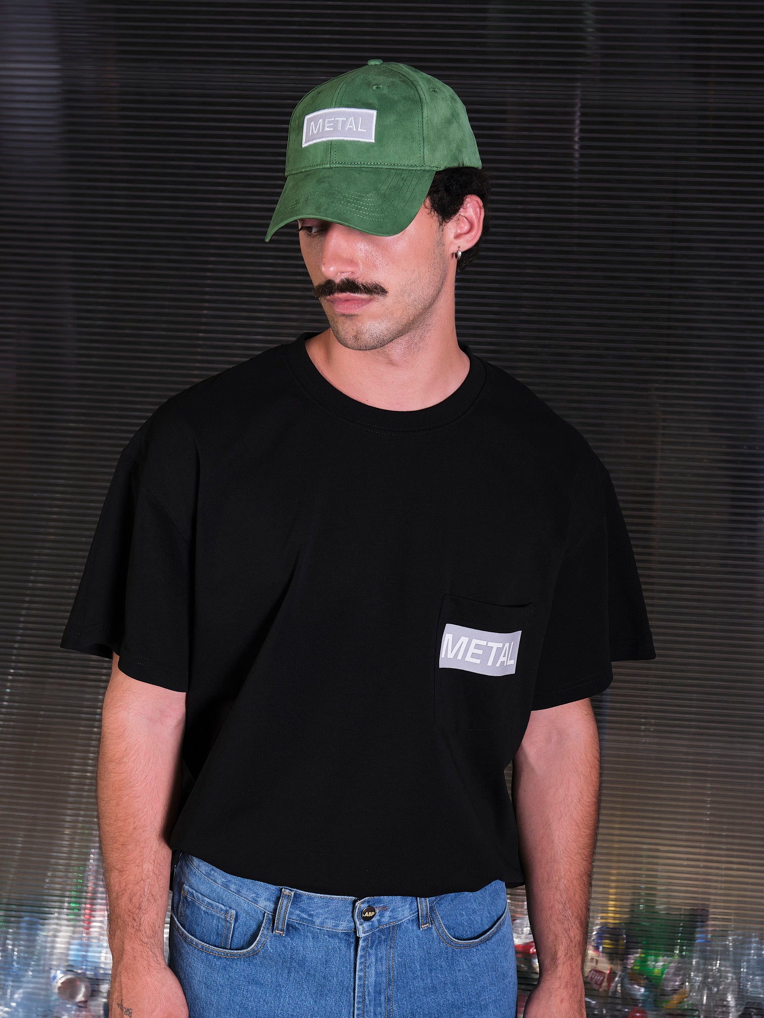 bABP Metal green eco-suede hat from the Signature Collection, portrait of a model with a mustache wearing a black pocket t-shirt