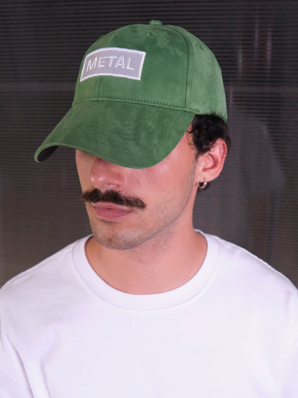 bABP Metal green eco-suede hat from the Signature Collection, portrait view of a model wearing a white t-shirt