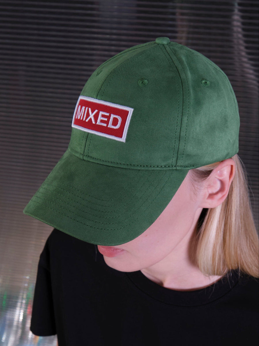 bABP Mixed green eco-suede hat from the Signature Collection, side portrait view on a female model with blonde hair, featuring the red "MIXED" logo patch