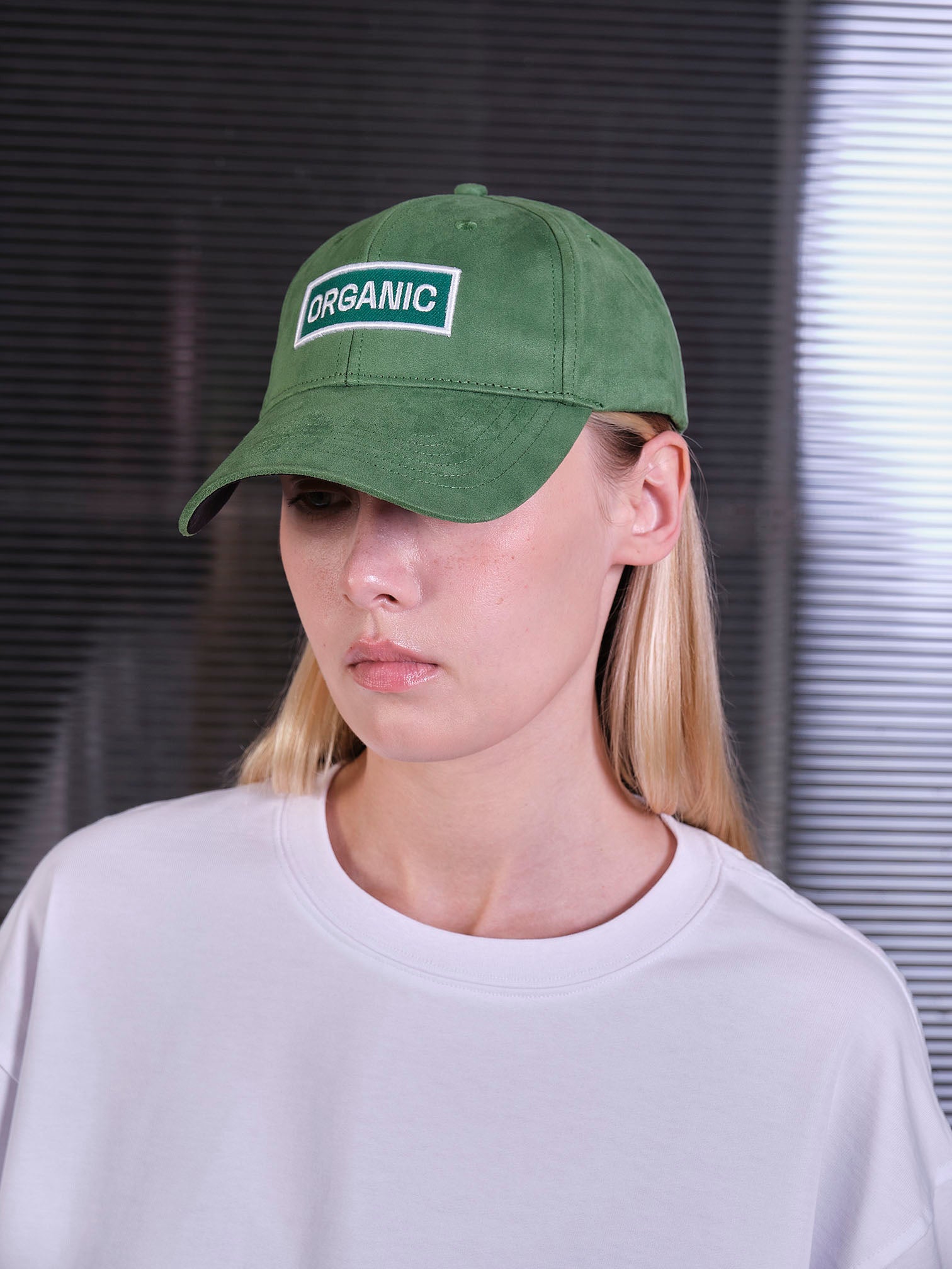 bABP Organic green eco-suede hat from the Signature Collection, portrait view on a female model with blonde hair wearing a white t-shirt