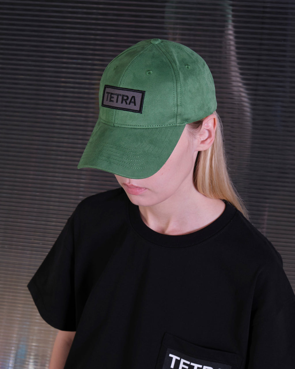 bABP Tetra green eco-suede hat from the Signature Collection, portrait view on a model in a black t-shirt, highlighting the unique embroidered patch and high-quality fabric