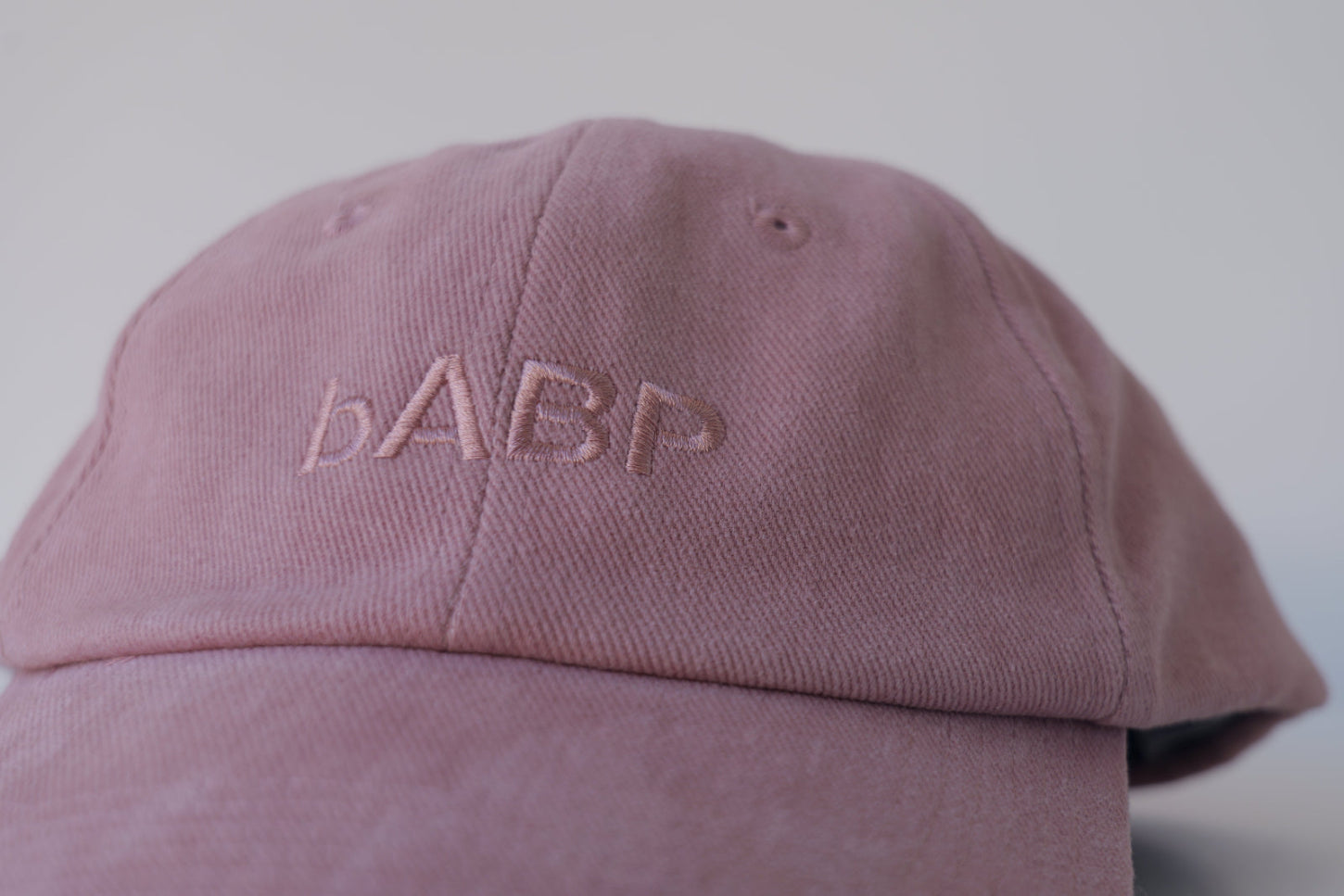 Front view of bABP B-SIDE pink cotton hat with tonal logo embroidery, featured on a professional light gray studio background, premium streetwear headwear