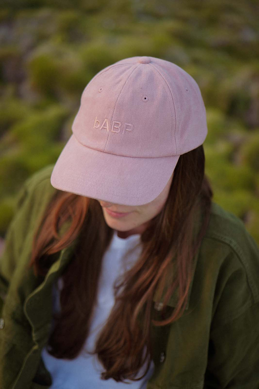 Lifestyle portrait of a person wearing the bABP B-SIDE pink heavy cotton hat with tonal "bABP" logo embroidery, reflecting the "Port of Design: Los Angeles" and "Street Approved Goods" series aesthetic