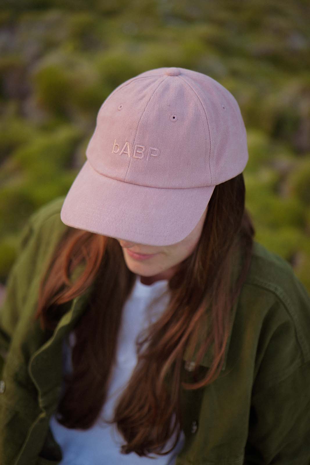 Lifestyle portrait of a person wearing the bABP B-SIDE pink heavy cotton hat with tonal "bABP" logo embroidery, reflecting the "Port of Design: Los Angeles" and "Street Approved Goods" series aesthetic