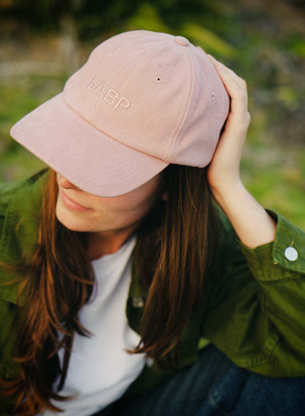 Lifestyle portrait of a person wearing the bABP B-SIDE pink heavy cotton hat, highlighting the "Port of Design: Los Angeles" series aesthetic in an urban setting
