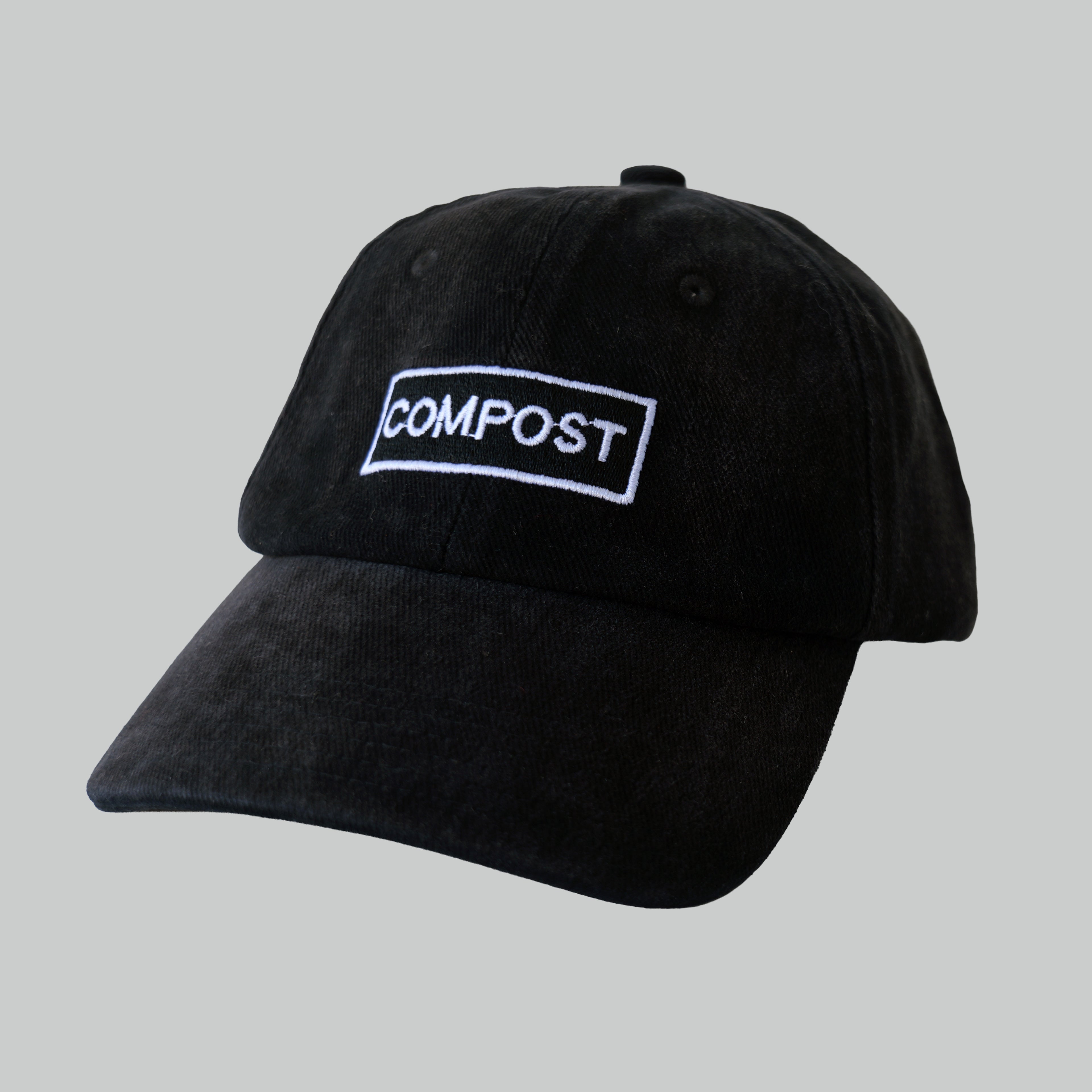 Professional studio shot of bABP B-SIDE: FRESH COMPOST black washed cotton hat with white logo embroidery, featured on a matching off-white grey background to highlight the tonal contrast