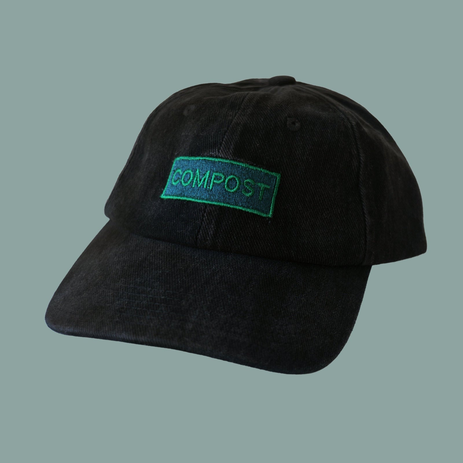 Front view of bABP "COMPOST" black washed cotton hat with a vibrant green embroidered logo patch, B-SIDE collection