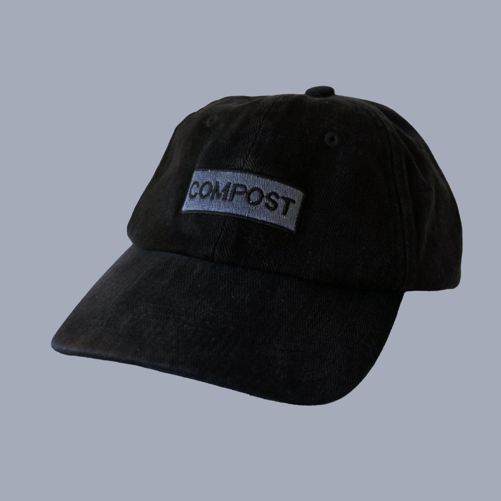 Front view of bABP "COMPOST" black washed cotton hat with a grey embroidered logo patch, B-SIDE collection