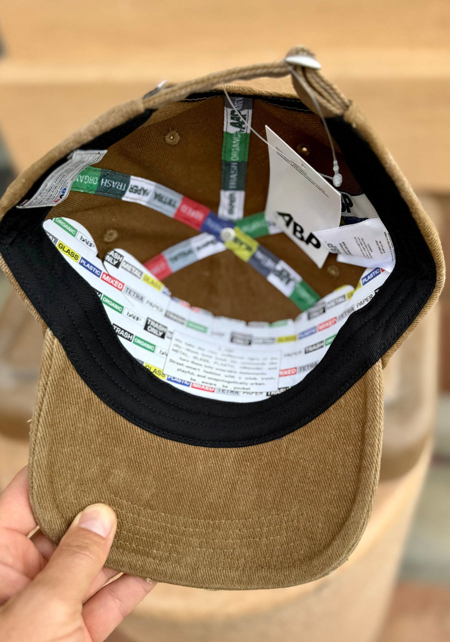 Internal view of bABP tan dad hat featuring custom branded logo taping, premium tags, and a street-approved hidden message on the labels; a detail-oriented design that cleared customs and creative blocks to reach the streets