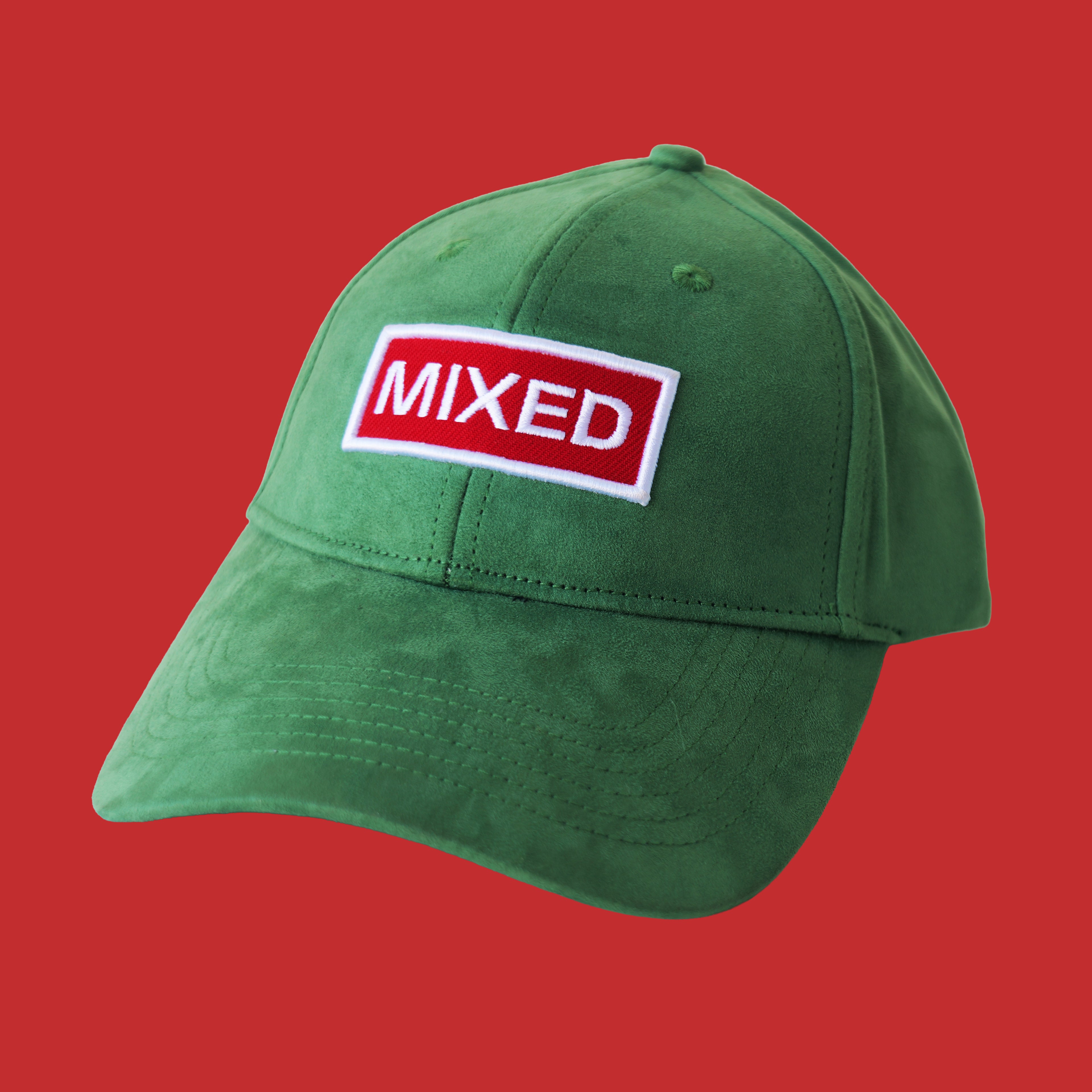 Professional studio shot of bABP "MIXED" green eco-suede hat with a red and white embroidered patch, featured on a matching monochromatic rust-red background