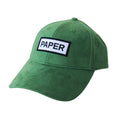 Professional studio shot of bABP "PAPER" green eco-suede hat with a white and black embroidered logo patch, featured on a matching clean white background