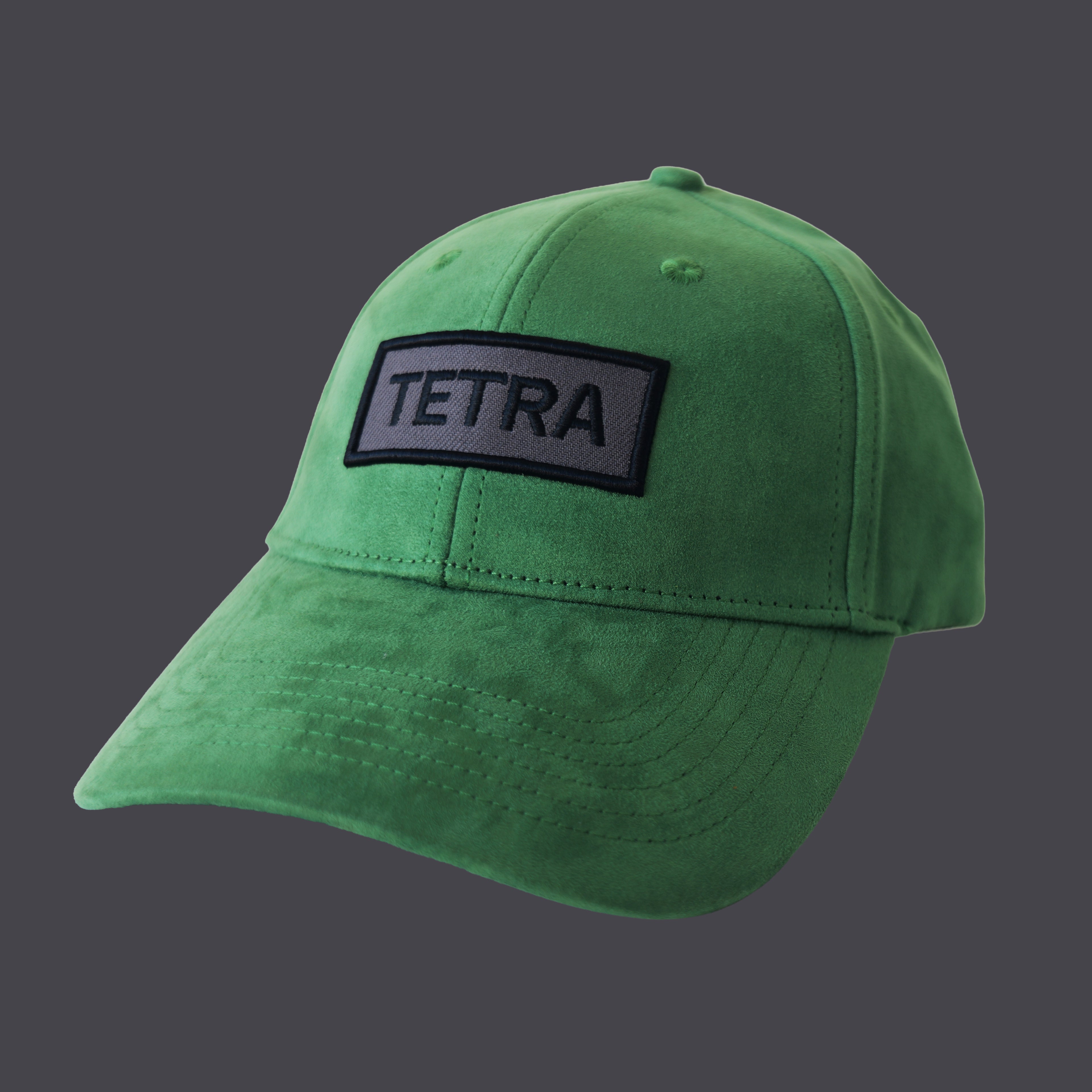 Professional studio shot of bABP "TETRA" green eco-suede hat with a grey and black embroidered logo patch, featured on a matching monochromatic grey background