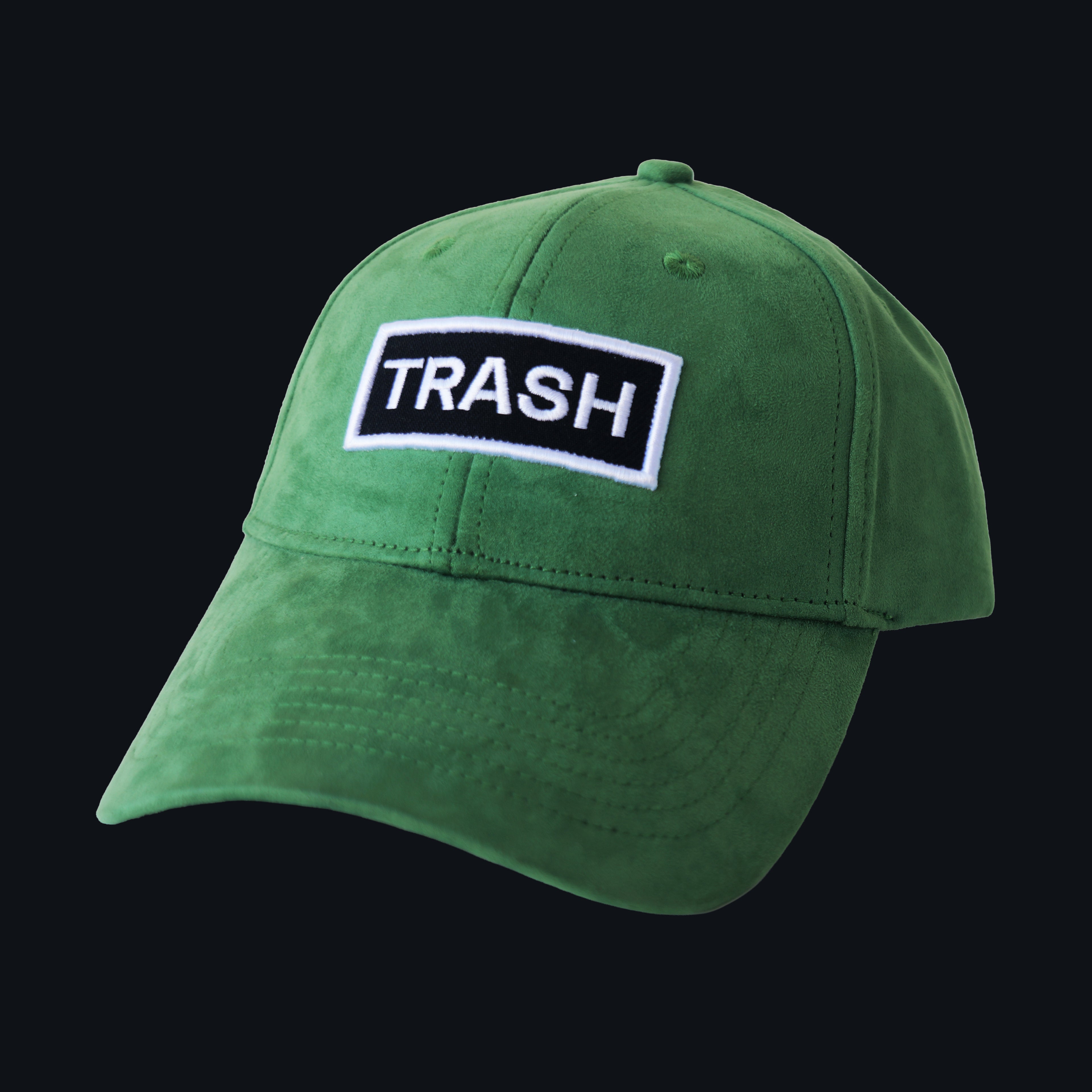Professional studio shot of bABP "TRASH" green eco-suede hat with a black and white embroidered logo patch, featured on a matching monochromatic black background