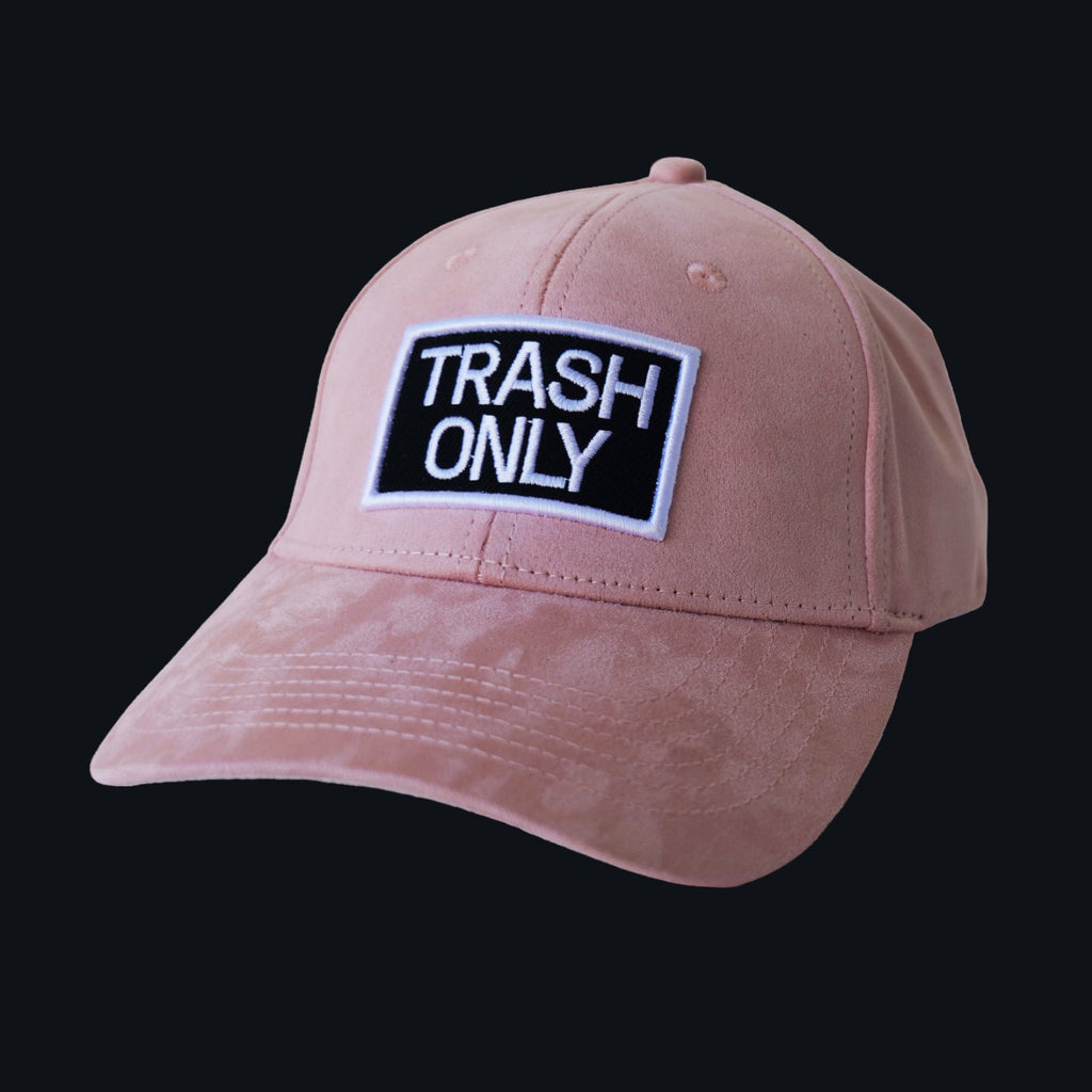 Professional studio shot of bABP "TRASH ONLY" pink eco-suede hat with a black and white embroidered logo patch, featured on a matching monochromatic black background